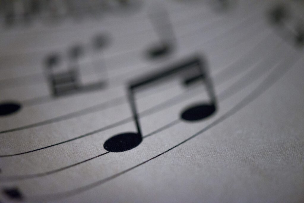 Blurry, abstract, macro vintage tablecloth imprinted with musical symbols. black notes on white background